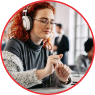 Mulher sorrindo com fones de ouvido, curtindo música em ambiente de trabalho, ideal para temas de curadoria musical, experiência de áudio e aprendizado no rock.