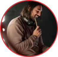 Produtor ou músico em estúdio com fone de ouvido, representando a criação musical, produção de áudio e conteúdo para o mercado de rock.